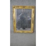 A 19th century gilt framed wall mirror, of rectangular form, the corners decorated with abundant