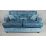 A contemporary Victorian style sofa, upholstered in blue velour, with a buttoned back, on turned bun