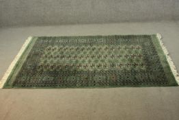 A Pakistan Bokhara green ground hand made rug. L.186 W.128cm.
