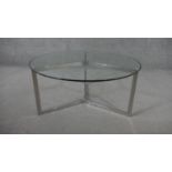 A 1970's style chrome coffee table, the circular plate glass top on a tri-form base. H.40 Diam.86cm