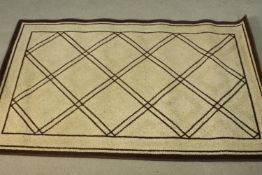 A Moroccan beige ground rug. L.192 W.125cm.