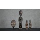 An African carved tribal mask on stand, a pair of carved African figures and a larger African carved