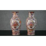 A pair of early 20th century Chinese hand painted vases with panels decorated with flower baskets