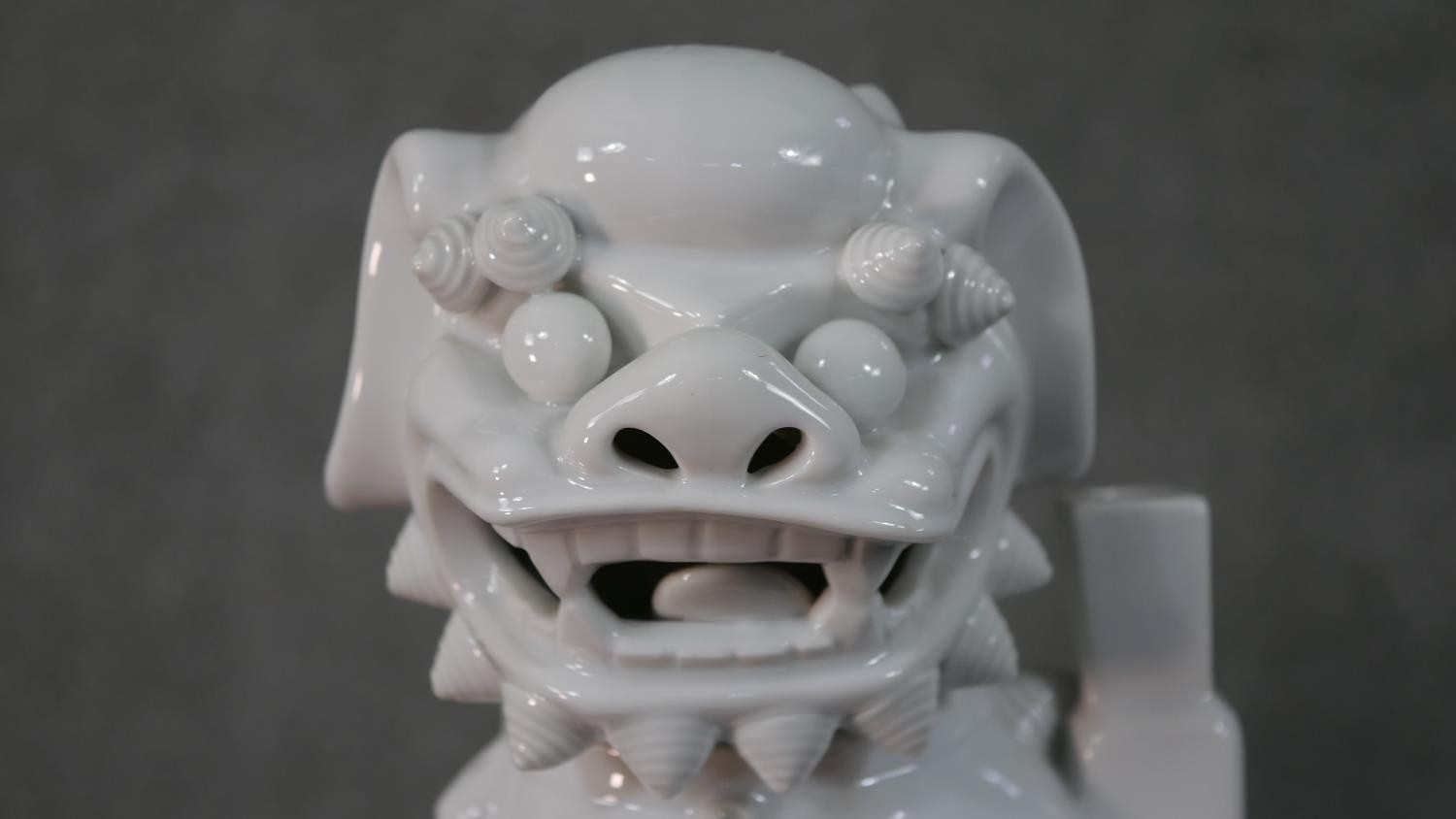 A 20th century blanc de chine Chinese ceramic foo dog on pierced square base. H.35 W.12 D.10cm - Image 2 of 6