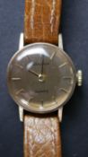 A ladies gold tone metal watch by Bulova with tan leather strap.