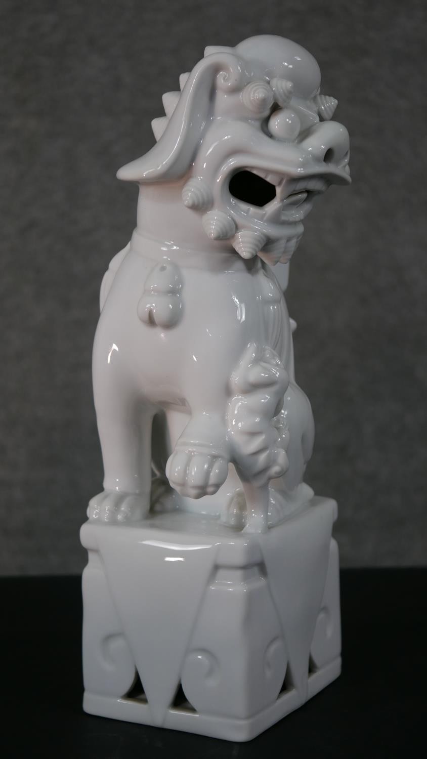 A 20th century blanc de chine Chinese ceramic foo dog on pierced square base. H.35 W.12 D.10cm - Image 3 of 6