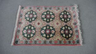A Persian silk Qum rose ground hand made rug. L.77 W.57cm.