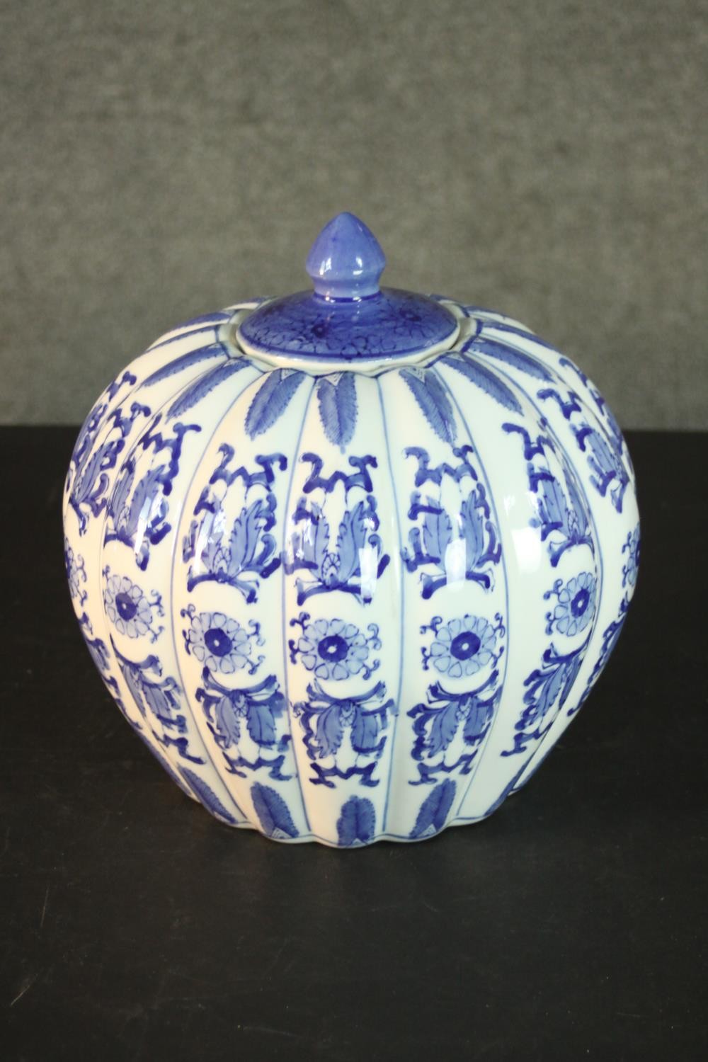 A blue and white Chinese ceramic gourd form lidded jar with stylised floral design and character