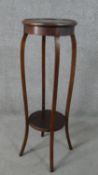 An Edwardian mahogany jardinière stand, with a circular top on curved legs, joined by a circular