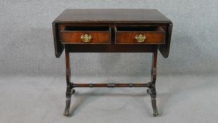 A George III style mahogany sofa table, with two drop leaves, two short drawers, on pierced end