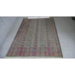 A Bokhara motif rug on a green ground within multiple borders. L.200 W.140 cm