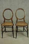 A pair of late Victorian ebonised balloon back dining chairs, with faux walnut painted detail, a