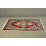 A Pakistan Bokhara red ground handmade rug. L.165 W.98cm.