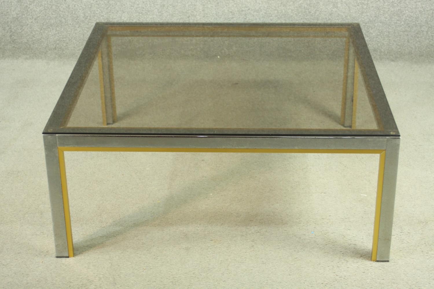 Manner of Janetti, a 1970's coffee table, with a tinted glass coffee top on a chrome and brass