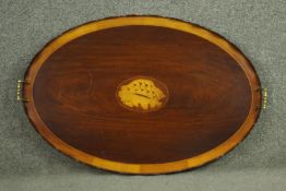 A George III style mahogany oval tray with brass handles, crossbanded with satinwood, centred by a