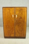 A small walnut wardrobe, the two doors with scrolling ivorine handles, the interior with hanging