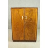 A small walnut wardrobe, the two doors with scrolling ivorine handles, the interior with hanging