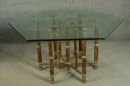 A hexagonal bamboo dining table, with a plate glass top, the base formed of lashed bamboo. H.73 W.