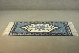 A Tibetan cream ground handmade rug. H.168 W.72cm