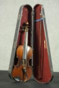 A cased 20th century violin and bow, having a two piece back and ebony finger board, bearing a label
