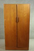 A 1960s Austin Suite two door teak wardrobe, with two doors, the interior with hanging space and