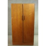 A 1960s Austin Suite two door teak wardrobe, with two doors, the interior with hanging space and