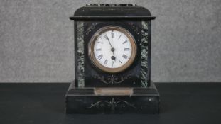 A Victorian black slate and green serpentine architectural mantle clock, adorned with a white