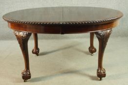 An oval mahogany extending dining table, with a wind-out mechanism and two additional leaves, with a