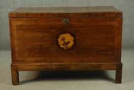 An 18th century walnut chest on stand, crossbanded, with a marquetry inlaid dragon roundel, on