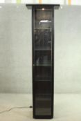 An ebonised ash display cabinet, with a glazed door and sides, with glass shelves to the interior.