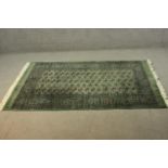 A Pakistan Bokhara green ground hand made rug. L.186 W.128cm.