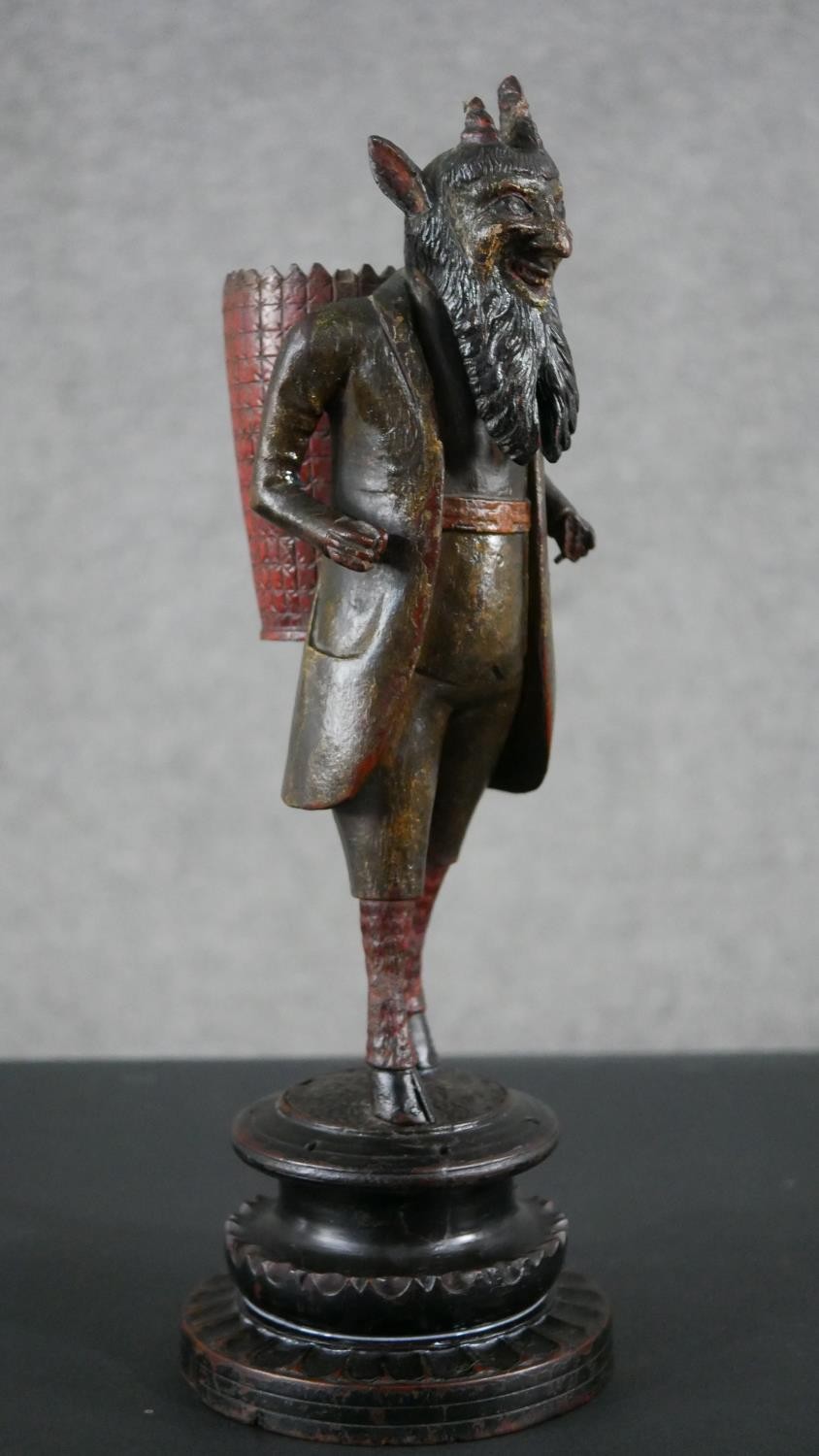 A 19th century carved black forest faun match holder, a pedestal base with red basket on his back. - Image 2 of 6