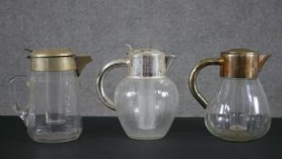 Three silver plated early 20th century blown glass lemonade jugs with internal ice coolers, one with
