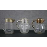 Three silver plated early 20th century blown glass lemonade jugs with internal ice coolers, one with