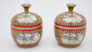 A pair of 19th century Chinese Famille rose hand painted porcelain lidded pots decorated with panels