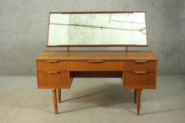 A 1960's Austin Suite dressing table with mirror, over an arrangement of five drawers around a