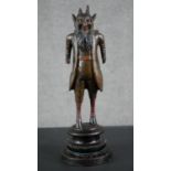 A 19th century carved black forest faun match holder, a pedestal base with red basket on his back.