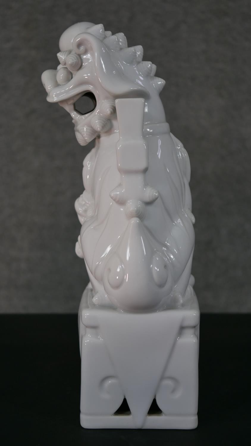 A 20th century blanc de chine Chinese ceramic foo dog on pierced square base. H.35 W.12 D.10cm - Image 5 of 6