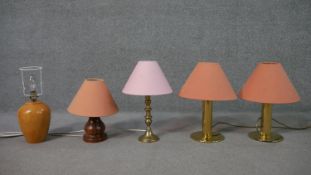 A collection of five table lamps, including a brass pair, with salmon coloured shades, on