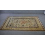 A Persian Kashan biscuit ground hand made rug. L.217 W.136cm.