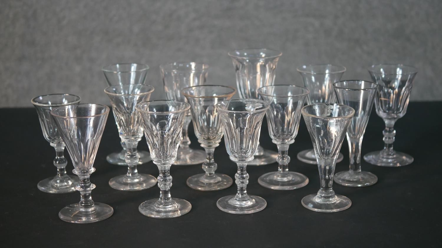 A collection of fourteen 19th and early 20th century trumpet shaped sherry and cordial glasses, some
