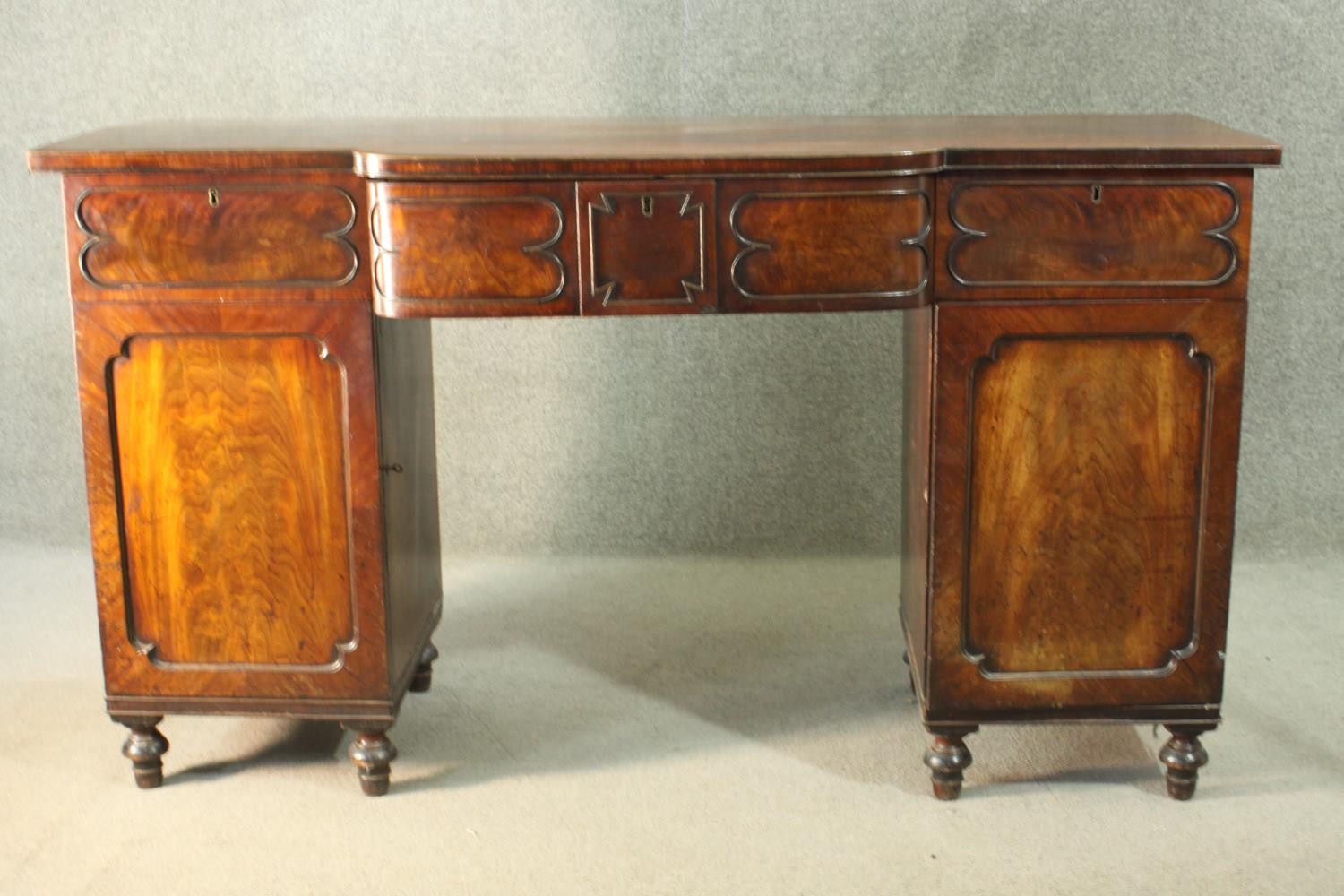 A Regency mahogany bow fronted pedestal sideboard, the central drawer fitted for cutlery, flanked by