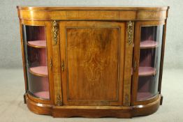 A Victorian walnut and marquetry inlaid credenza, with a central cupboard door flanked by two curved