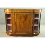 A Victorian walnut and marquetry inlaid credenza, with a central cupboard door flanked by two curved