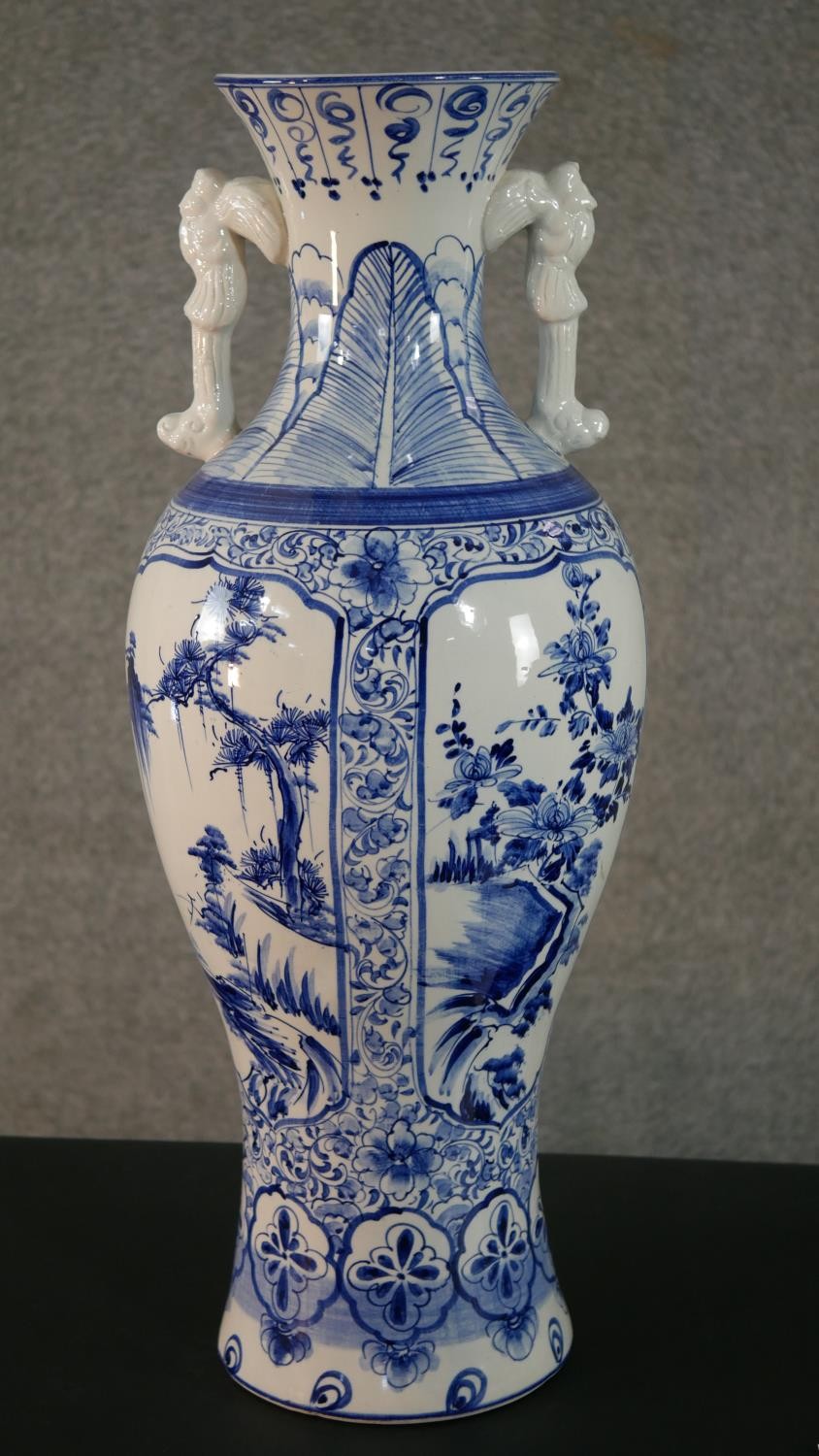 A large blue and white Chinese porcelain twin handled vase, one side decorated with a river scene