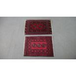 Two red ground Afghan rugs. H.72 W.50cm (Largest)