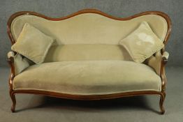 A Victorian walnut framed hump back sofa, upholstered in green velour, on cabriole legs. H.96 W.