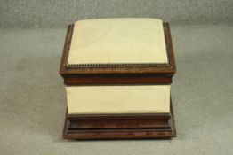 A small walnut Ottoman stool, the lid and sides upholstered in ivory fabric with a studded edge,