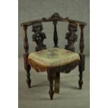 A late 19th century Italian corner chair, carved with a mask to the back rail, over two ornately