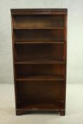 A mahogany bookcase, with a dentil cornice over four shelves, on shaped bracket feet. H.170 W.80 D.